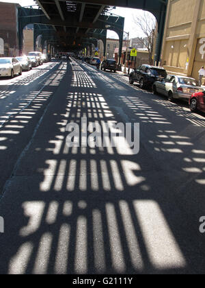 steel structure of elevated subway casts shadow on 23rd Street in Long Island City. Connects Queens and Manhattan. Stock Photo