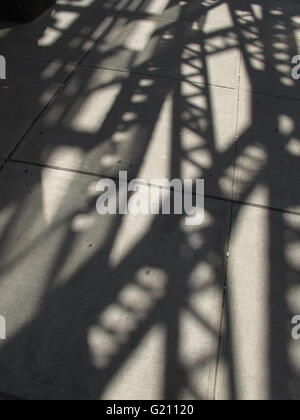 steel structure of elevated subway casts shadow on 23rd Street sidewalk in Long Island City. Connects Queens and Manhattan. Stock Photo