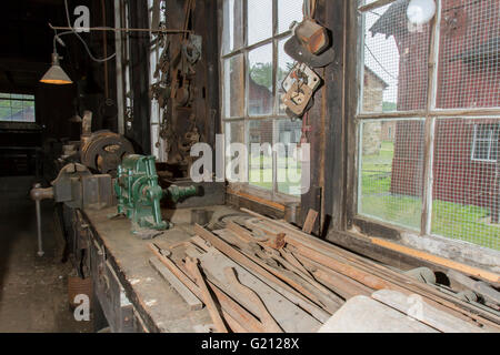 Wood and tools on workbench in old machine shop. Stock Photo