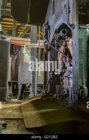 Close up of steam engines on vintage locomotives in maintenance roundhouse. Stock Photo