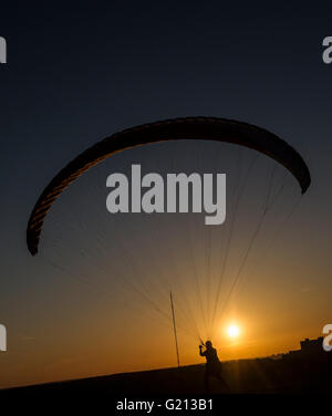 Berlin, Germany. 21st Apr, 2016. A paraglider waits for optimal thermal lift on Drachenberg hill in Berlin, Germany, 21 April 2016. Photo: PAUL ZINKEN/dpa/Alamy Live News Stock Photo