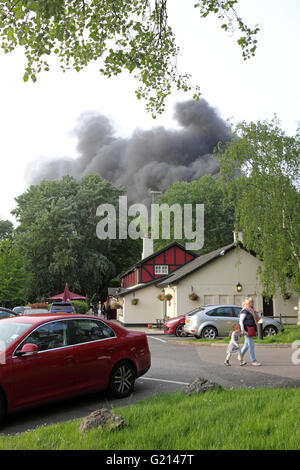 Worcester Park, Surrey, UK. 21st May 2016. Clouds of black, billowing smoke rise from a fire on B284 Old Malden Lane in Worcester Park, Surrey. At around 7.30pm multiple fire crews, police and ambulances attended the fire beside the Hogsmill Toby Carvery Pub. Police have confirmed that burning tyres at an industrial yard caused the excessive amounts of black smoke. By around 8.00pm the fire was under control. Credit:  Julia Gavin UK/Alamy Live News Stock Photo