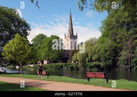 Stratford-upon-Avon, England, UK; 22nd May, 2016. A young woman takes a selfie on the banks of the River Avon at Stratford, with Holy Trinity Church in the background. Credit:  Andrew Lockie/Alamy Live News Stock Photo