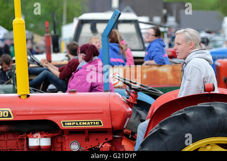 Royal Welsh Spring Festival, May 2016 - A young woman tractor driver waits for start of the classic vehicle and vintage tractor parade in the main display arena on the second day of the Royal Welsh Spring Festival.