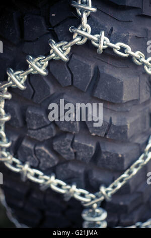 Close up shot of some chains wrapped around a car's tire. Stock Photo