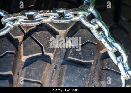 Close up shot of some chains wrapped around a car's tire. Stock Photo