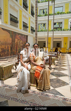 Two ladies sit inside the Fragrant Nature Hotel in Cochin India Stock Photo