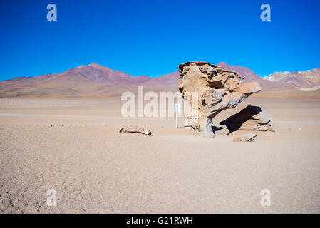 Dirt road at high altitude with sandy desert and scenic rock formation on the Andean highlands. Road trip to the famous Uyuni Sa Stock Photo