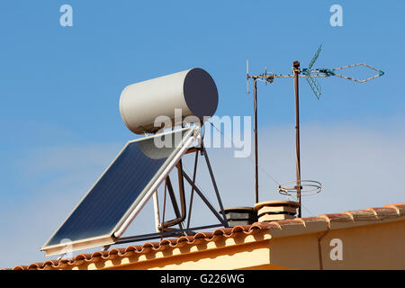 Solar panel for heating water and television antennas, in a roof of a house Stock Photo