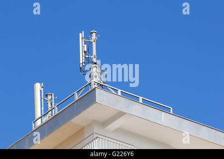 Mobile antenna in a building, against blue sky Stock Photo