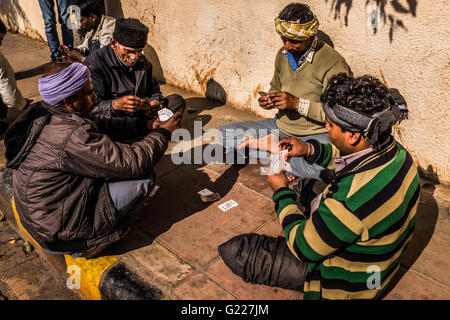 Men sat on pavement playing cards, Delhi, India Stock Photo