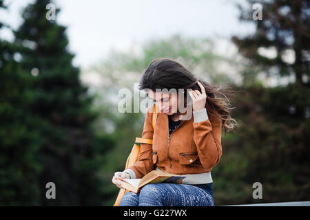 Funny picture modern RC Drone Quadcopter with camera flying on green field in front of a curious cow Stock Photo