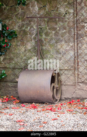 Close up of an old vintage garden roller leaning against a wall, UK Stock Photo