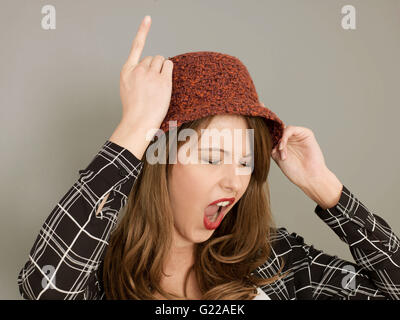 Portrait of A Woman Being or Acting Silly Pulling Faces and Acting the Fool With Finger Gestures and Humorous Facial Expressions Stock Photo