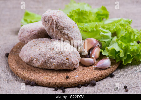 fresh raw cutlet with herbs and tomatoes, mushrooms, pepper Stock Photo