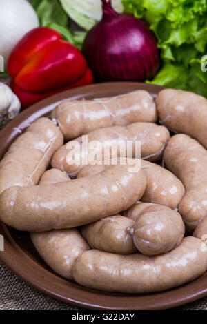 White raw sausage on cutting board with a quail eggs Stock Photo
