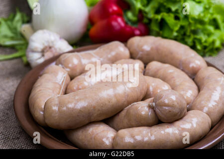 White raw sausage on cutting board with a quail eggs Stock Photo