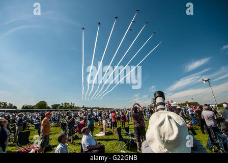 The RAF's Red Arrows running in for their first public display of 2016 at the Shuttleworth Premiere show with crowd watching. Audience under blue sky Stock Photo