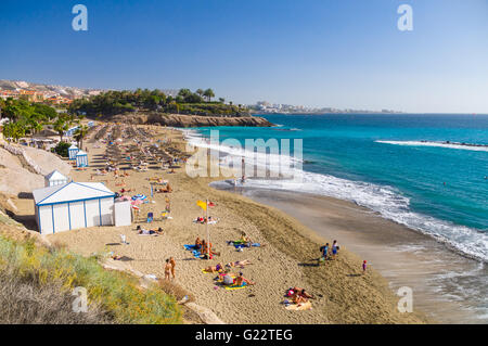 COSTA ADEJE, SPAIN - JANUARY 25, 2016: People enjoying sunny weather on the picturesque Playa El Duque beach. Stock Photo