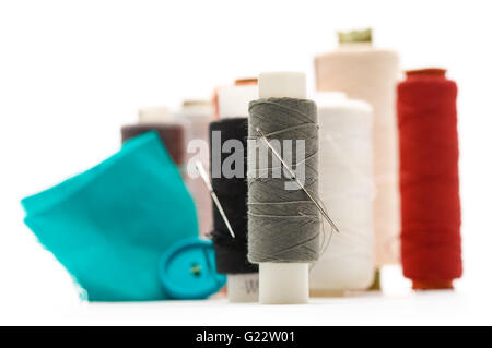 Thread bobbins and needles on white background Stock Photo