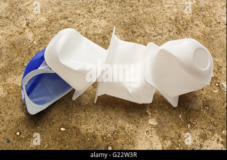Empty crushed plastic yogurt pots on soil Stock Photo
