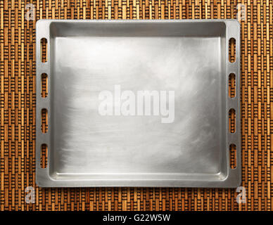 Empty metal oven tray on rod background Stock Photo
