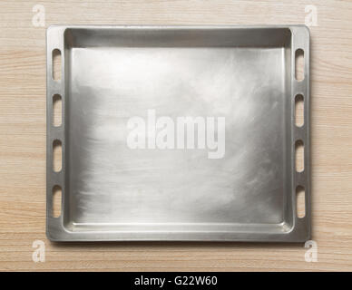 Empty metal oven tray on wooden background Stock Photo