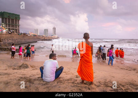 Colombo, Sri Lanka,   23rd May, 2016. Young novice monks and others play in the sea at sunset at Galle Face Green. It is a public holiday, and day three  of Vesak celebrations, which commemorates the birth of Buddha, his attaining enlightenment and his passing away on the full moon day of May which fell this year on May 21. Colombo, Sri Lanka. Stock Photo