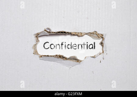 The word confidential appearing behind torn paper. Stock Photo
