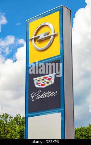 Cadillac and Opel logo on a sign outside the car or automotive dealership against the blue sky Stock Photo