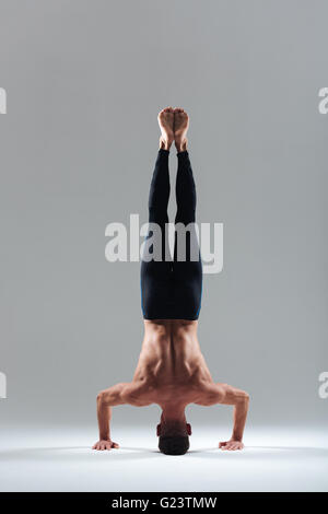 Man doing headstand isolated on a white background Stock Photo