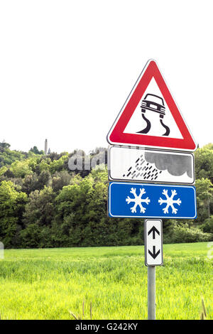 Road Sign Caution curves ahead in the meadow Stock Photo