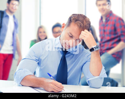 handsome teacher writing in notebook Stock Photo