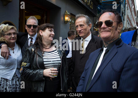 Teddy Boys gather outside a pub in Soho following a 40th anniversary of their infamous march on the BBC to protest that they wanted more rock and roll on the radio, which they recreated today on May 14th 2016 in London, United Kingdom. Teddy Boy, also known as Ted, is a British subculture typified by men wearing clothes that were partly inspired by the styles worn by dandies in the Edwardian period, which tailors had attempted to re-introduce in Britain after World War II. It is sometimes inaccurately written that the Teddy Boy style and phenomenon appeared in Britain during the mid 1950s as a Stock Photo