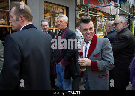 Teddy Boys gather outside a pub in Soho following a 40th anniversary of their infamous march on the BBC to protest that they wanted more rock and roll on the radio, which they recreated today on May 14th 2016 in London, United Kingdom. Teddy Boy, also known as Ted, is a British subculture typified by men wearing clothes that were partly inspired by the styles worn by dandies in the Edwardian period, which tailors had attempted to re-introduce in Britain after World War II. It is sometimes inaccurately written that the Teddy Boy style and phenomenon appeared in Britain during the mid 1950s as a Stock Photo