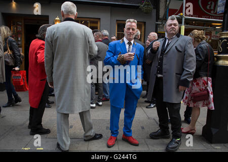 Teddy Boys gather outside a pub in Soho following a 40th anniversary of their infamous march on the BBC to protest that they wanted more rock and roll on the radio, which they recreated today on May 14th 2016 in London, United Kingdom. Teddy Boy, also known as Ted, is a British subculture typified by men wearing clothes that were partly inspired by the styles worn by dandies in the Edwardian period, which tailors had attempted to re-introduce in Britain after World War II. It is sometimes inaccurately written that the Teddy Boy style and phenomenon appeared in Britain during the mid 1950s as a Stock Photo