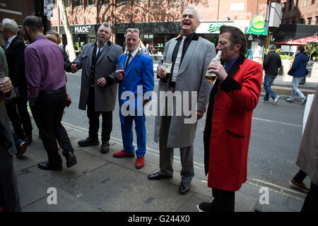 Teddy Boys gather outside a pub in Soho following a 40th anniversary of their infamous march on the BBC to protest that they wanted more rock and roll on the radio, which they recreated today on May 14th 2016 in London, United Kingdom. Teddy Boy, also known as Ted, is a British subculture typified by men wearing clothes that were partly inspired by the styles worn by dandies in the Edwardian period, which tailors had attempted to re-introduce in Britain after World War II. It is sometimes inaccurately written that the Teddy Boy style and phenomenon appeared in Britain during the mid 1950s as a Stock Photo