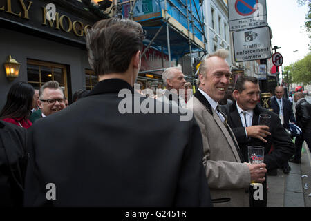 Teddy Boys gather outside a pub in Soho following a 40th anniversary of their infamous march on the BBC to protest that they wanted more rock and roll on the radio, which they recreated today on May 14th 2016 in London, United Kingdom. Teddy Boy, also known as Ted, is a British subculture typified by men wearing clothes that were partly inspired by the styles worn by dandies in the Edwardian period, which tailors had attempted to re-introduce in Britain after World War II. It is sometimes inaccurately written that the Teddy Boy style and phenomenon appeared in Britain during the mid 1950s as a Stock Photo