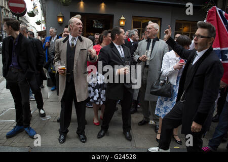 Teddy Boys gather outside a pub in Soho following a 40th anniversary of their infamous march on the BBC to protest that they wanted more rock and roll on the radio, which they recreated today on May 14th 2016 in London, United Kingdom. Teddy Boy, also known as Ted, is a British subculture typified by men wearing clothes that were partly inspired by the styles worn by dandies in the Edwardian period, which tailors had attempted to re-introduce in Britain after World War II. It is sometimes inaccurately written that the Teddy Boy style and phenomenon appeared in Britain during the mid 1950s as a Stock Photo