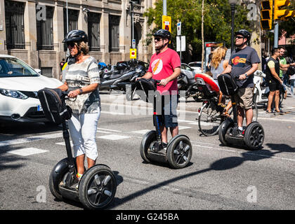 A Group of sightseeing tourists on Segways crossing a road, Barcelona, Catalonia, Spain. Stock Photo