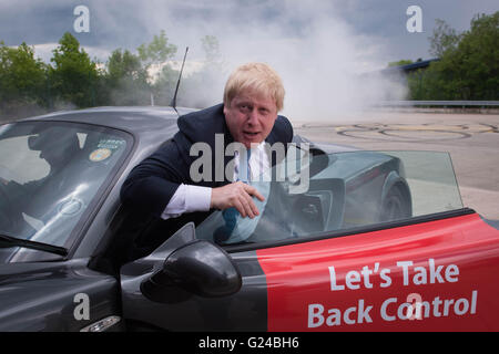 Boris Johnson, emerges from a Ginetta sport car after the company's Chief Executive, Lawrence Tomlinson, performed a series of 'doughnuts' as the former Mayor of London visited the factory in West Yorkshire, as part of his tour on the Vote Leave campaign bus. Stock Photo