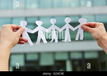 Family with people made of paper held in hands Stock Photo