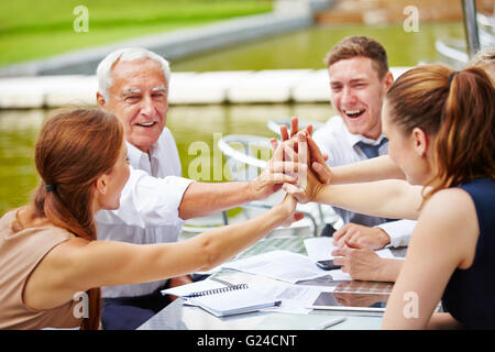 Successful business people doing high five in a meeting for motivation Stock Photo