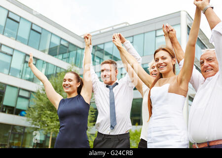 Happy cheering business team holding together the hands up Stock Photo