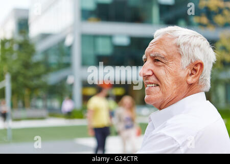 Happy senior man sitting in summer in the city Stock Photo