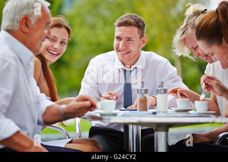 Successful group of businesspeople having meeting in a coffee shop outdoors Stock Photo