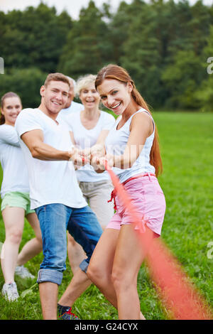 People playing tug of war with rope during a competition outdoors Stock Photo