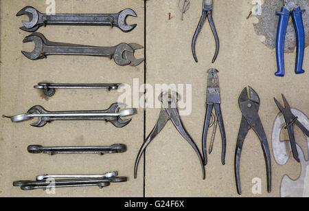 Various vintage old metal tools on wooden board in workshop Stock Photo