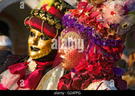 Venice Carnival: Piazzetta San Marco, Venice, Italy.  Two elaborately costumed masked revellers pose by the Basilica di San Marco Stock Photo