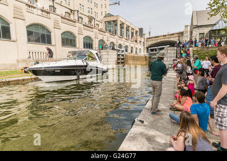 Tourists looking at a yacht passing through the Rideau Canal locks in Ottawa, Ontario, Canada. Stock Photo